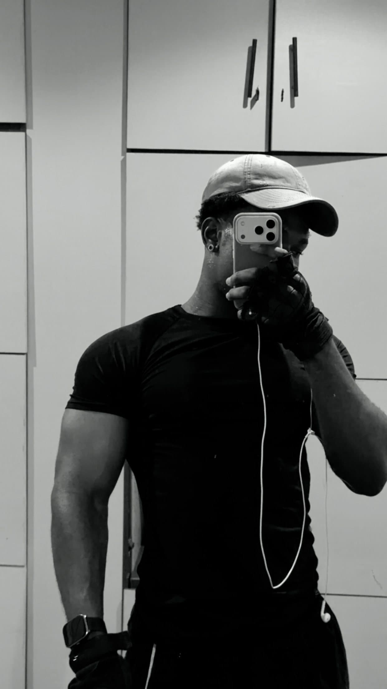 Tife in the clean black compression tee, mirror selfie showing the fit at the chest and arms